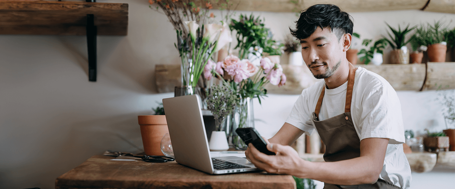 business owner paying bills in his local plant shop