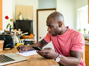 Man looking at computer and phone