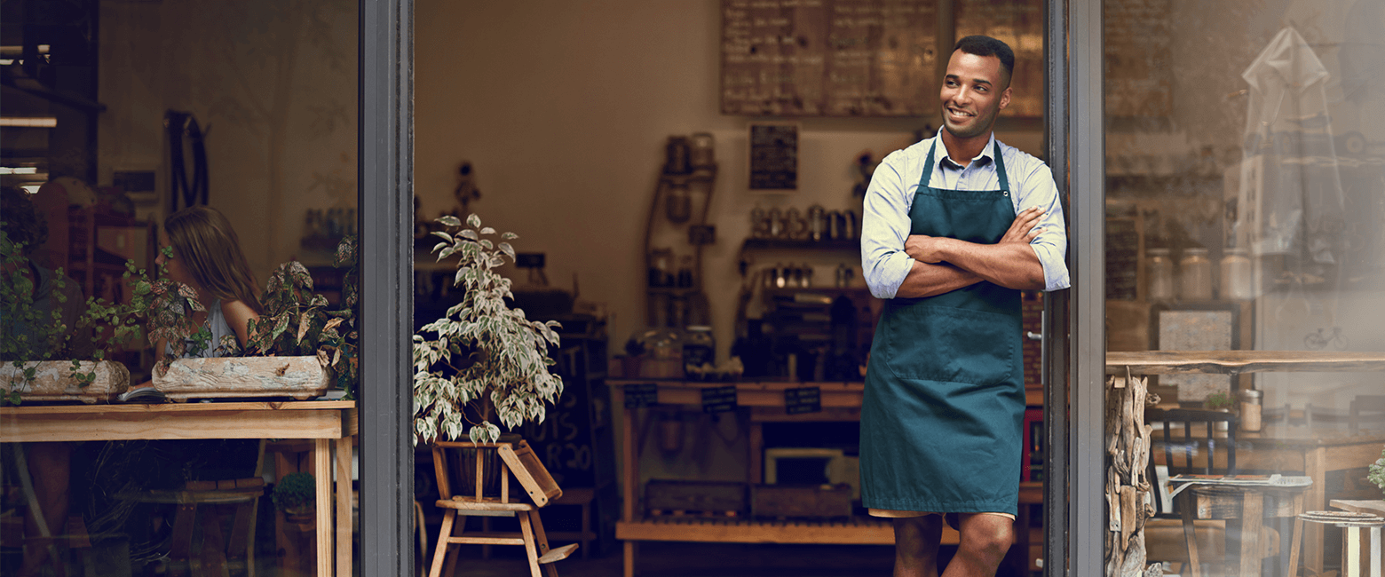 happy business owner in front of his coffee shop