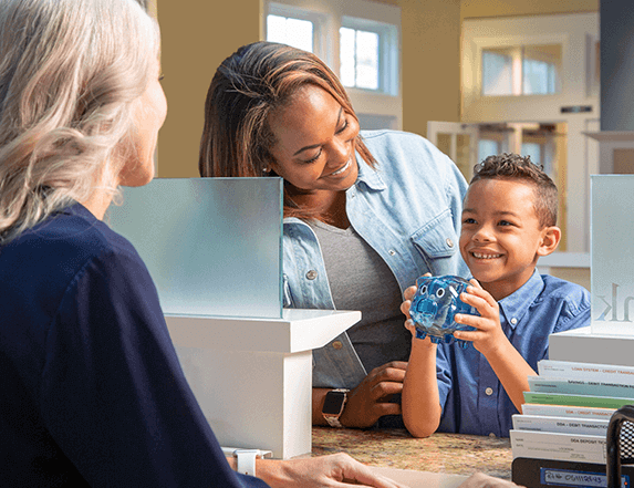 banker helping a kid with his piggy bank